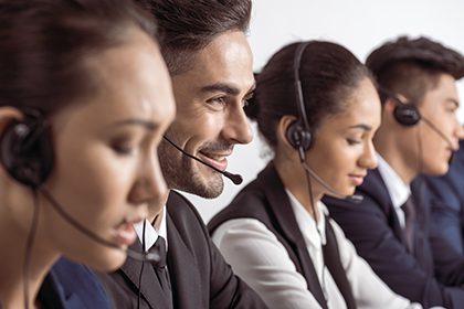 Close-up view of call center operators in headsets working toget Close-up view of call center operators in headsets working together